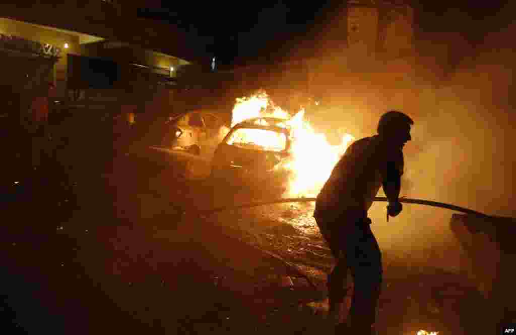 Lebanese civil defense firefighters put out a fire at the site of a car bomb attack in the Shi&#39;ite neighborhood of Shayyah, a suburb of Beirut.