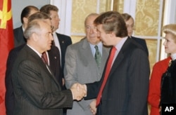 Soviet leader Mikhail Gorbachev shakes hands with New York real estate tycoon Donald Trump, at the State Department in Washington, Dec. 9, 1987 prior to a luncheon in Gorbachev's honor.