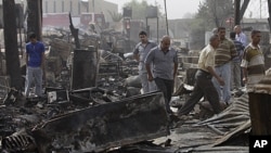 People inspect the scene of rocket attack at a residential complex in Baghdad, July 5, 2011