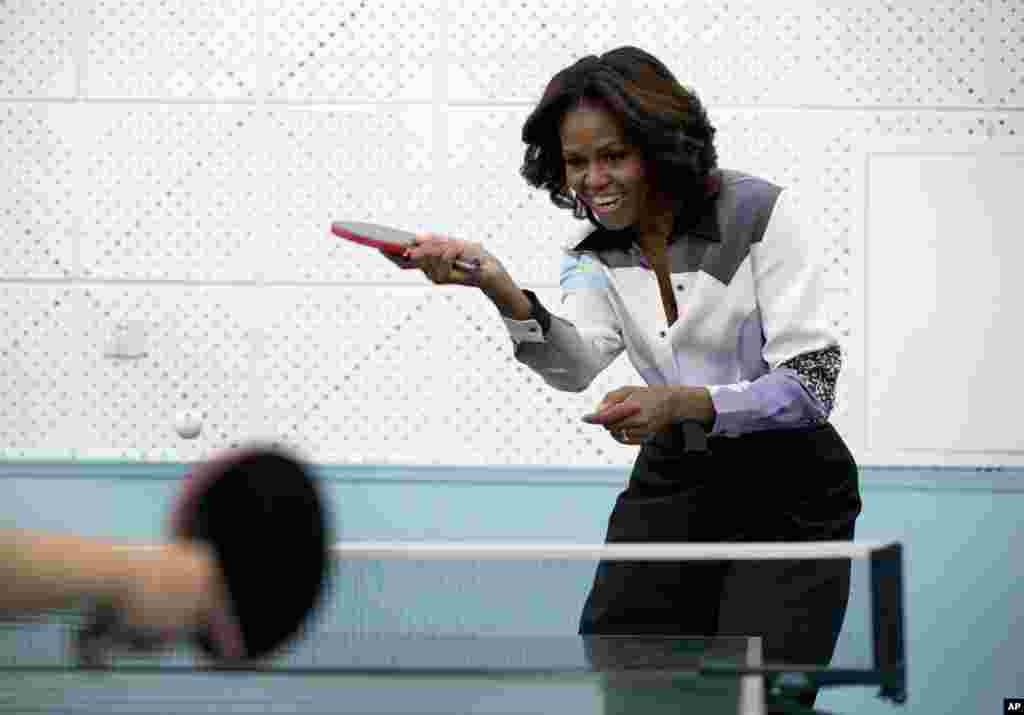 U.S. first lady Michelle Obama plays table tennis at the Beijing Normal School, a school that prepares students to attend colleges overseas, March 21, 2014. 