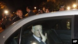 Greece's Prime Minister George Papandreou waves to journalists while exiting the Presidential Palace after a meeting with Greek President Karolos Papoulias and opposition leader Antonis Samaras, in Athens Sunday, Nov. 6 2011.