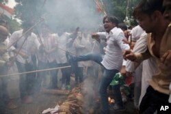 Activists of India's opposition Congress party's youth wing protesting against Monday’s rebel attack in Punjab state burn an effigy representing Prime Minister Narendra Modi and Punjab state Chief Minister Parkash Singh Badal in New Delhi, India, July 27,