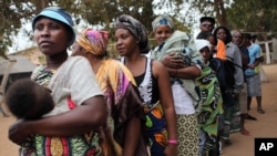 FILE - Angolans queue at a voting station in Kicolo, Luanda, Angola to cast their ballots, Aug. 31, 2012. 