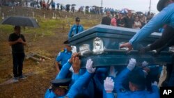 In this Sept. 29, 2017, photo, police lift the coffin of fellow officer Luis Angel Gonzalez Lorenzo, killed during the passage of Hurricane Maria when he tried to cross a river in his car, during his funeral in Aguada, Puerto Rico.