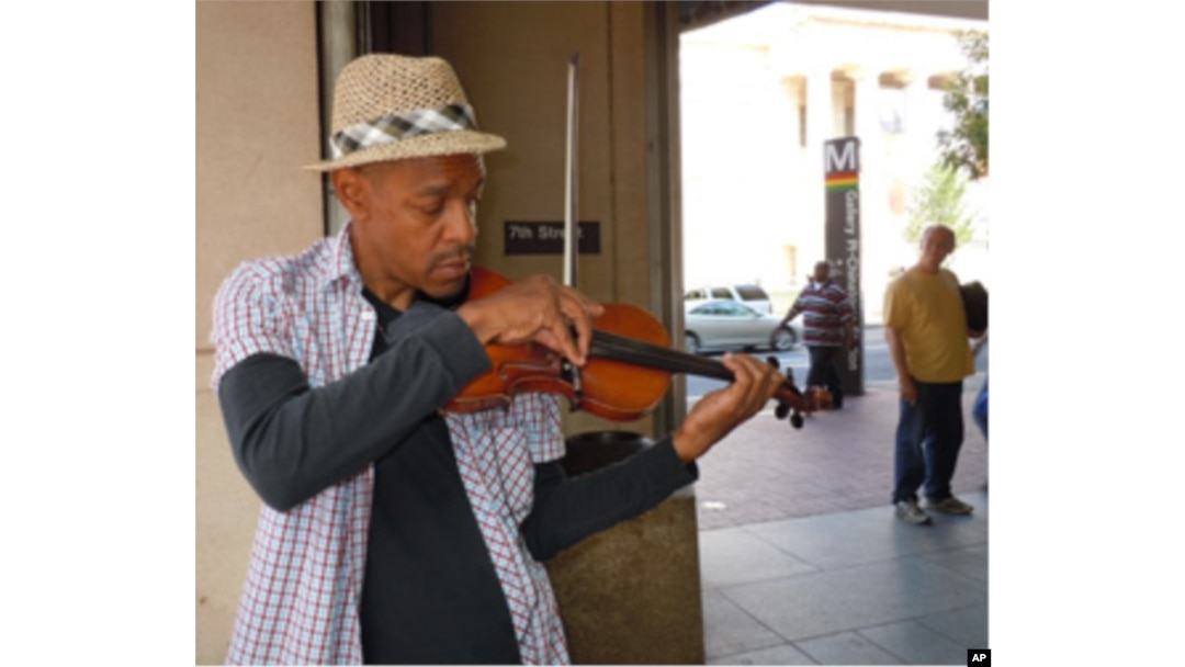 Street musician Raycurt Johnson plays patriotic music near a subway stop in downtown Washington
