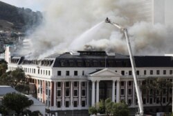 Firefighters work at the parliament as a fire flares up again, in Cape Town, South Africa, Jan. 3, 2022.