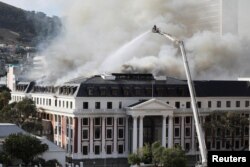 Des pompiers travaillent au parlement alors qu'un incendie se déclare à nouveau, au Cap, en Afrique du Sud, le 3 janvier 2022.