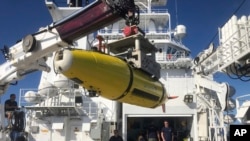 An autonomous underwater vehicle carrying high frequency sonar images of the Japanese aircraft carrier Akagi is loaded onto the research vessel Petrel, Sunday, Oct. 20, 2019, off Midway Atoll in the Northwestern Hawaiian Islands. (AP Photo/Caleb Jones)