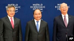 Vietnamese Prime Minister Nguyen Xuan Phuc, center, Chinese Vice Premier Hu Chunhua, left, and Klaus Schwab, executive chair of the World Economic Forum, pose prior to the World Economic Forum on ASEAN Wednesday, Sept. 12, 2018 . (AP Photo/Bullit Marquez, Pool)