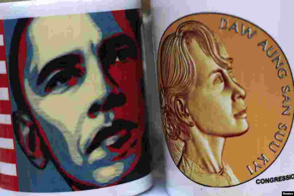 The portrait of U.S. President Barack Obama is seen printed on a cup which is placed next to another with the portrait of Aung San Suu Kyi at a shop in Yangon November 16, 2012. Obama leaves on Saturday for a trip to Asia that will include a historic stop