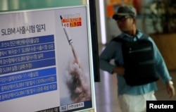 FILE - A passenger walks past a TV screen broadcasting a news report on North Korea's submarine-launched ballistic missile fired from North Korea's east coast port of Sinpo, at a railway station in Seoul, South Korea, Aug. 24, 2016.