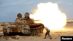 A fighter from Libyan forces allied with the U.N.-backed government fires a shell with a Soviet-made T-55 tank at Islamic State fighters in Sirte, Libya, Aug. 2, 2016. 