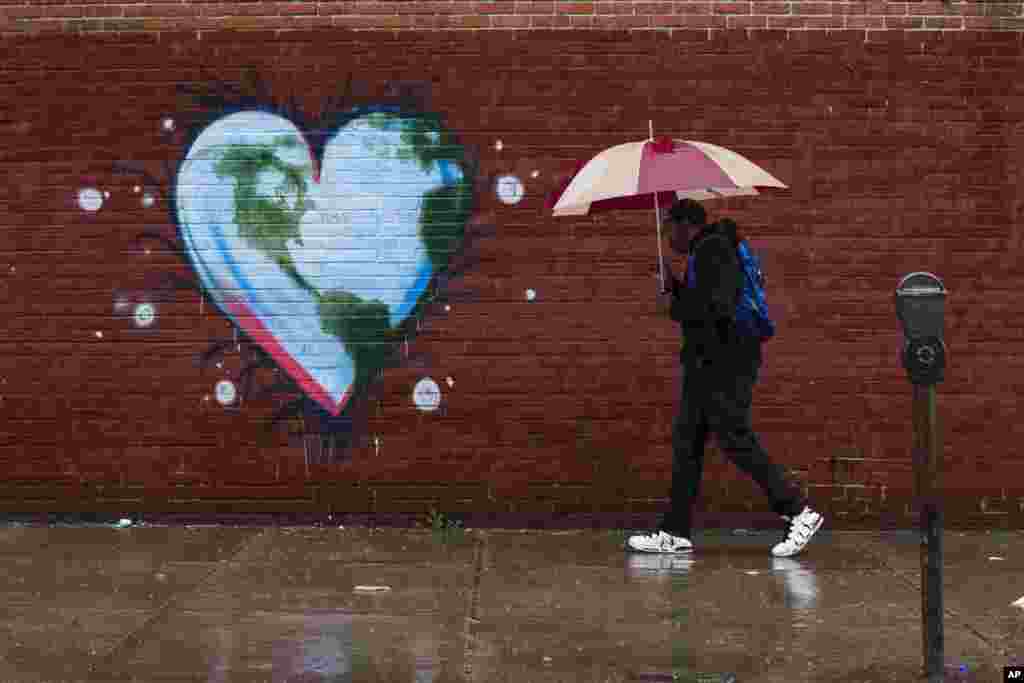 A man walks past a mural the day before Earth Day, in Philadelphia, Pennsylvania.