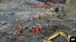 In this photo taken Saturday, Mar. 30, 2013, rescuers search through rocks and debris at a gold mine after a mudslide in Gyama village, in Maizhokunggar County of Lhasa, Tibet.