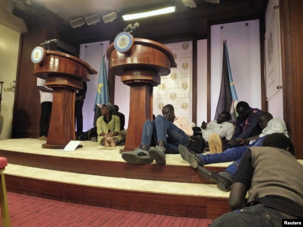 FILE - Journalists are seen on the podium following sounds of gunshots before a news conference by South Sudan President Salva Kiir, First Vice President Riek Machar and other government officials inside the Presidential State House in Juba, South Sudan, July 8, 2016.
