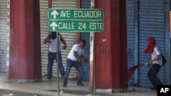 Manifestantes tiran piedras a la policía durante las protestas que derivaron en la derogación de la ley de venta de tierras, anunciada este lunes por el presidente Ricardo Martinelli.