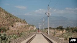 Une femme traverse la ligne inachevée du train Kombolcha-Djibouti dans une zone rurale de la région d'Amhara, en Éthiopie, le 13 décembre 2020.