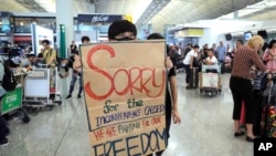 13일 홍콩 국제공항에서 시위자가 최근 빚어진 공항 파행 운영에 대해 사과하는 포스터를 들고 있다. 