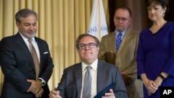 在能源部常务副部长布鲁耶特(左)、白宫办公厅代理主任马尔瓦尼和环境质量委员会主席纽梅尔(右)簇拥下，美国国家环境保护局局长惠勒在环保局签署“平价清洁能源”规则。(2019年6月19日)