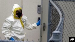 A firefighter dressed in protective suit walks into government mail screening facility outside Washington, DC April 17, 2013