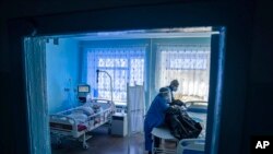 A medical worker prepares to transport the body of a COVID-19 victim at a hospital in Kakhovka, Ukraine, on Oct. 29, 2021.