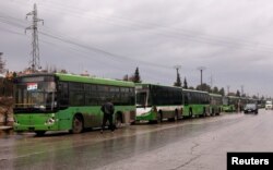 Buses wait to evacuate people from a rebel pocket in Aleppo, in the government-controlled al-Hamadaniah Stadium of Aleppo, Syria Dec. 14, 2016.