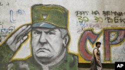 Žena prolazi pokraj graffita Ratka Mladića u Beogradu 2009. godine