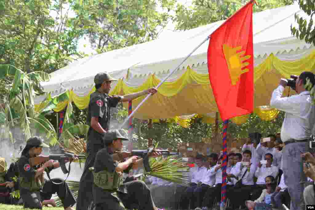 សិស្សសាលាវិចិត្រសិល្បៈលើកទង់ក្នុងឈុតមួយដែលជាសញ្ញាបង្ហាញពីជ័យជំនះនៃការរំដោះប្រទេសប្រឆាំងនឹងរបបប្រល័យពូជសាសន៍ប៉ុល ពតនៅវាលពិឃាឌជើងឯកនៃរាជធានីភ្នំពេញនៅថ្ងៃទី២០ឧសភា ២០១៦នេះ ដើម្បីរំលឹកដល់វិញ្ញានក្ខ័ណ្ឌអ្នកដែលស្លាប់នៅរបបប្រល័យពូជសាសន៏ចាប់ពីឆ្នាំ១៩៧៥ដល់១៩៧៩ក្នុងទិវា«ចងកំហឹង»ប្រឆាំងនឹងរបបប៉ុល ពត។ ( ឡេង ឡែន/VOA) 