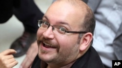 FILE - Jason Rezaian, an Iranian-American correspondent for the Washington Post smiles as he attends a presidential campaign of President Hassan Rouhani in Tehran, Iran.