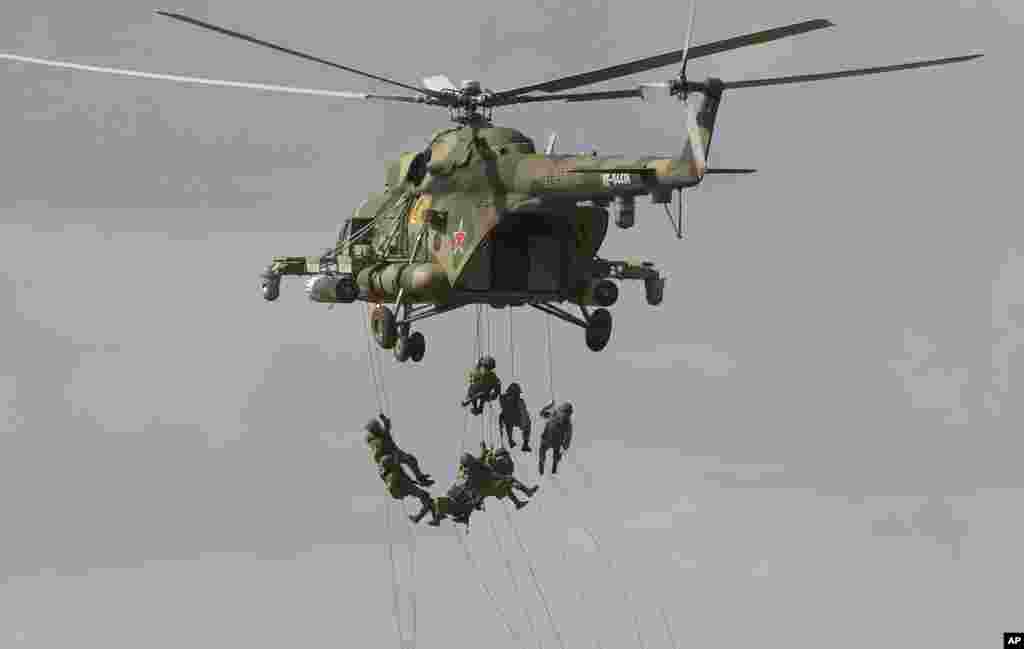 Soldiers abseil from a military helicopter over the training ground during strategic command and staff exercises Center-2019 at Donguz shooting range near Orenburg, Russia.