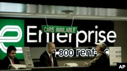FILE - Enterprise Rent-A-Car counter employees help a customer at Lambert International Airport in St. Louis, Jan. 27, 2006. The company looks to hire about 8,500 young people every year for a management training program.