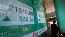 Papan indeks saham Hong Kong di sebuah bank lokal di Hong Kong (27/8). (AP/Vincent Yu)