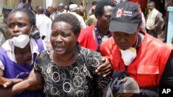 Red Cross staff console a woman after she viewed the body of a relative killed in Thursday's al-Shabab attack at a university in Garissa, northeastern Kenya, at the Chiromo funeral home in Nairobi, Kenya, April 7, 2015.