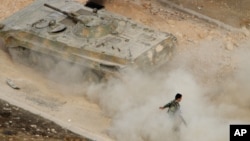 A Syrian APC moves raising dust in Harasta, northeast of Damascus, Syria, Oct. 22, 2015. 