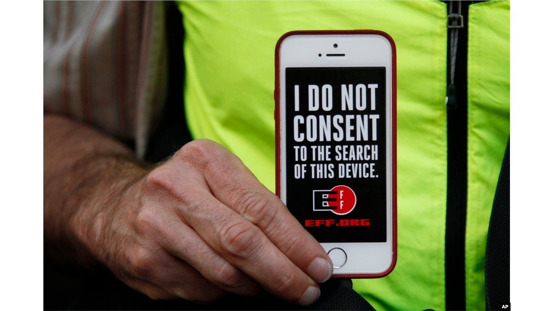 Un hombre muestra su iPhone durante una protesta en apoyo a la privacidad de información en San Francisco, California. Feb. 23, 2016.
