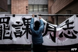 FILE - A student sets up a banner during a protest at the campus of Hong Kong’s leading university HKU in Hong Kong on January 20, 2016.