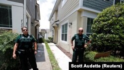 Des agents de police se tiennent à l'extérieur du domicile en Floride de l'ancien officier de police de Minneapolis, Derek Chauvin, accusé du meurtre de George Floyd  en Floride. (REUTERS / Scott Audette)