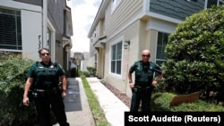 Des agents de police se tiennent à l'extérieur du domicile en Floride de l'ancien officier de police de Minneapolis, Derek Chauvin, accusé du meurtre de George Floyd en Floride. (REUTERS / Scott Audette)