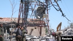 Fighters from the Kurdish People's Protection Units (YPG) inspect the damage at their headquarters after it was hit by Turkish airstrikes in Mount Karachok near Malikiya, Syria, April 25, 2017.