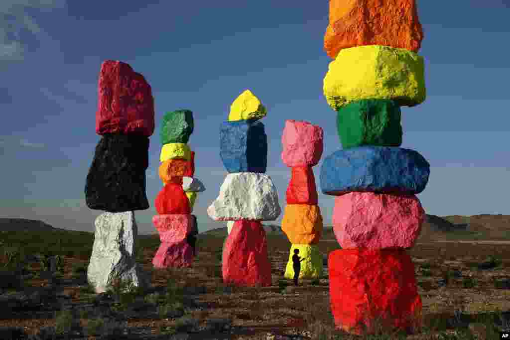 People visit the artwork titled Seven Magic Mountains by artist Ugo Rondinone near Jean, Nevada, USA.