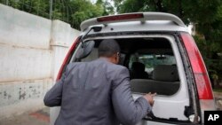 Director for the Somali television station Horn Cable looks at the smashed window of a car that was carrying journalists. (File)