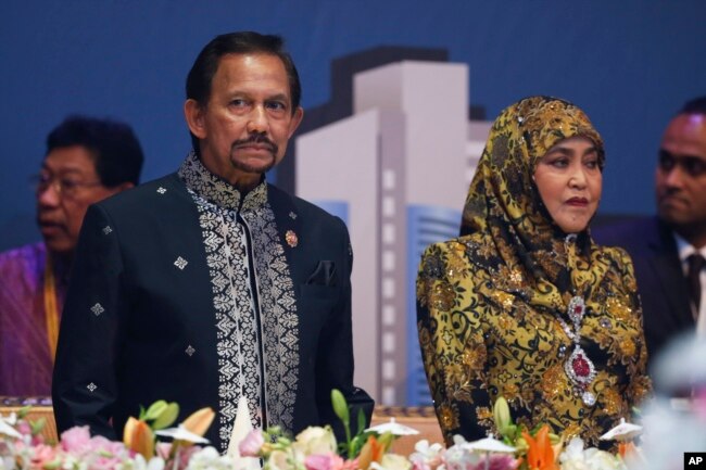 FILE - Brunei Sultan Hassanal Bolkiah, left, and wife Queen Saleha attends the Gala Dinner at the 27th ASEAN Summit in Kuala Lumpur, Malaysia.