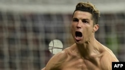 L'attaquant portugais du Real Madrid Cristiano Ronaldo jubile après avoir transformé un penalty lors du quart de finale aller de la ligue des champions contre la Juventus au stade Santiago Bernabeu de Madrid le 11 avril 2018