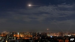 In this photo released by the Syrian official news agency SANA, shows missiles flying into the sky near international airport, in Damascus, Syria, Jan. 21, 2019