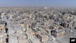FILE - This frame grab made from drone video shows damaged buildings in Raqqa, Syria, Oct. 19, 2017.
