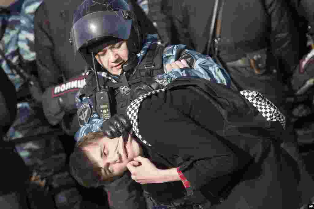 Police detain a protester in downtown Moscow, Russia. Thousands of people crowded into Moscow&#39;s Pushkin Square for an unsanctioned protest against the government.