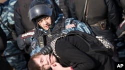  Police detain a protester in downtown Moscow, Russia, Sunday, March 26, 2017. 