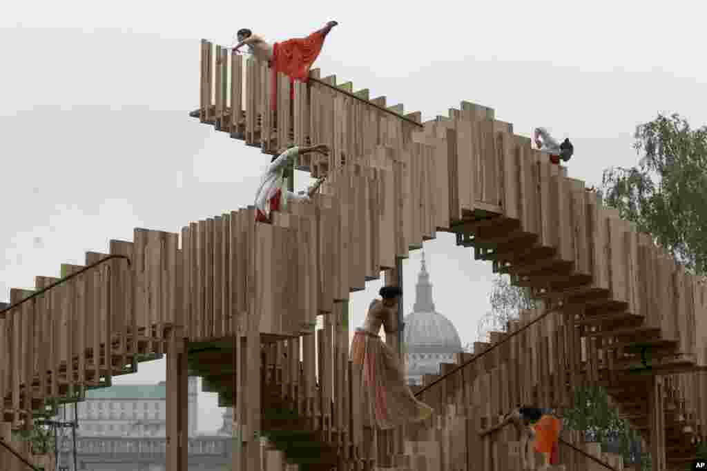 Dancers perform on the steps of an installation entitled &quot;Endless Stair&quot; outside the Tate Modern art gallery, with St. Paul&#39;s Cathedral partially visible in the background, during an event to launch the London Design Festival.