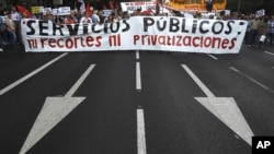 Manifestantes en una calle de Madrid se oponen a los recortes fiancieros y demandan más servicios públicos.