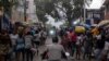La gente camina en un mercado callejero de Petion-Ville mientras las motocicletas pasan, en Puerto Príncipe, Haití, 24 de julio de 2021. REUTERS / Ricardo Arduengo